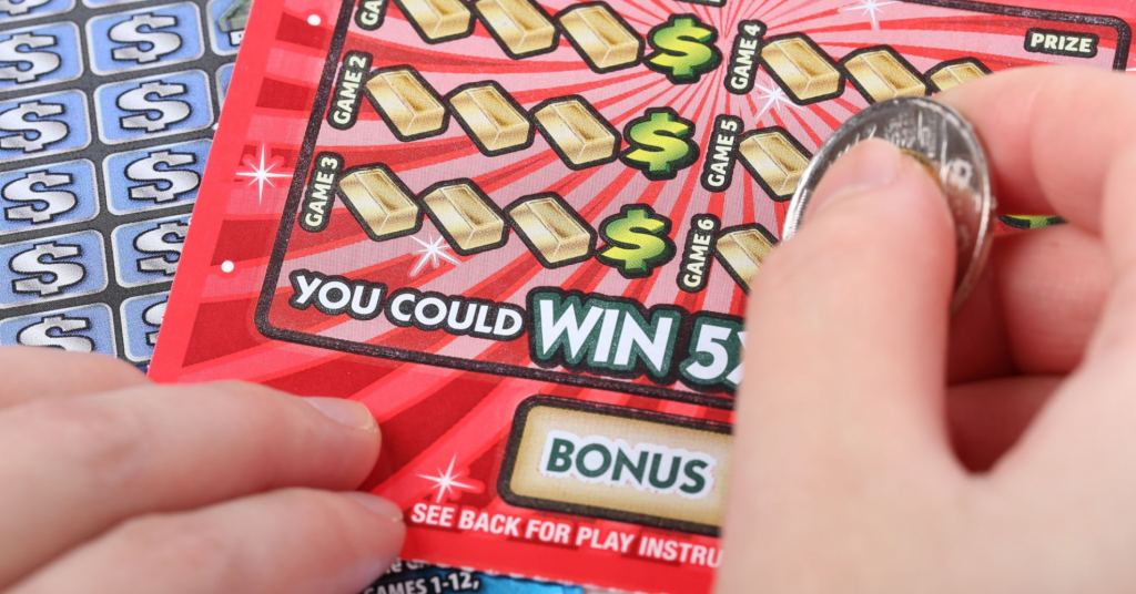 Cratch-off lottery ticket being played